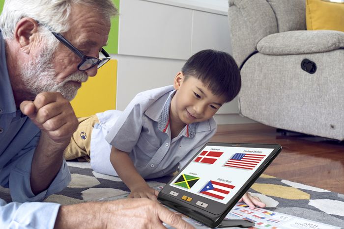 A grandfather and his grandson using exploré 12 to enlarge the flags of different countries. 